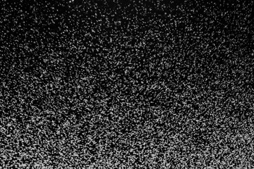 Black and white abstract image resembling snowfall at night or a starry sky, with countless white...