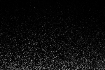 Black and white abstract image resembling snowfall at night or a starry sky, with countless white...