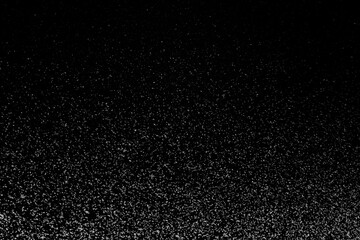 Black and white abstract image resembling snowfall at night or a starry sky, with countless white...