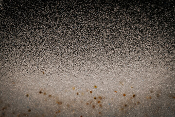Black and white abstract image resembling snowfall at night or a starry sky, with countless white...