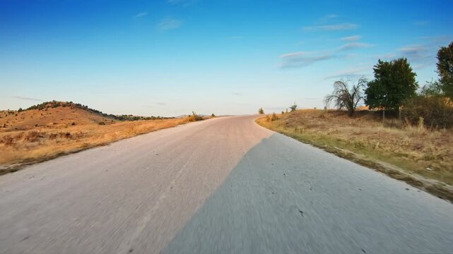 Beautiful unspoilt countryside, dry grass, bright summer day, POV car trip