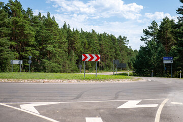 Bright sunny day at a rural roundabout surrounded by green trees in a tranquil landscape © Akshatha