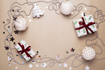 New Year card with Christmas gift boxes and silver decorations on beige background, copy space for text