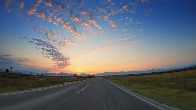 Beautiful flatland scenery, golden fields, sparse clouds sky, sundown, POV drive