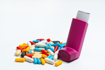 Multicolored tablets and capsules and aerosol spray for asthmatics, allergies, on white background. Bronchodilator medicine with salbutamol for patients with asthma, allergy, chronic pulmonary disease