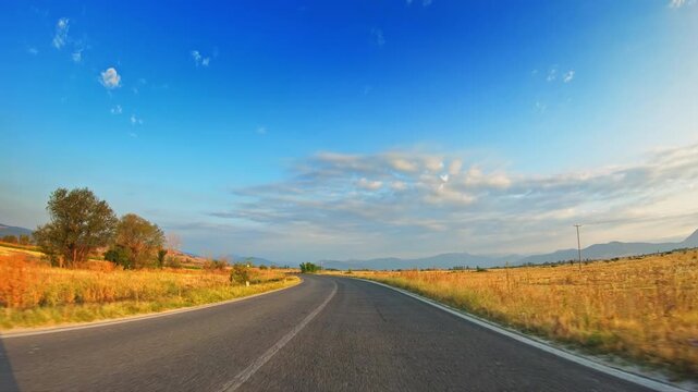 Bright summer day, cultivated golden fields, skyline, POV vehicle drive
