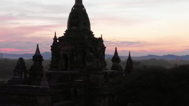 Ancient temples stand silhouetted against a vibrant sunset sky in bagan, myanmar
