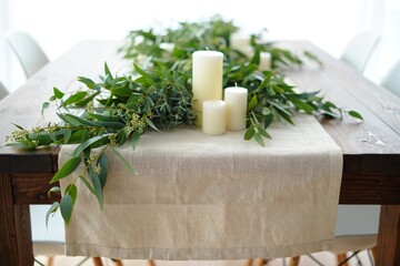Table setting with greenery and candles for a rustic style.