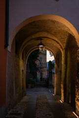 Obraz premium Charming evening scene in an ancient alleyway with warm lantern light illuminating the stone walls and path
