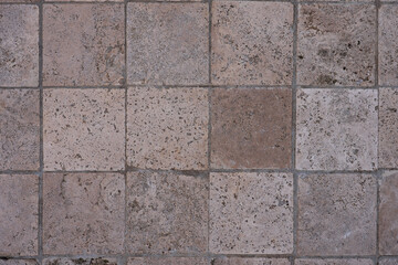 Textured stone tile floor with square pattern
