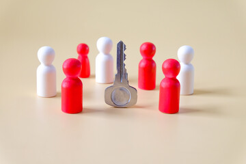 Wooden figure standing circle around the key.Business , teamwork, team spirit.