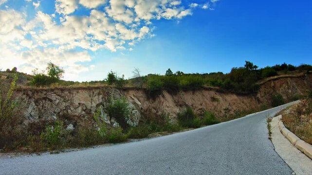 Amazing hilly nature, dry meadows, POV car trip on curvy narrow road, uphill