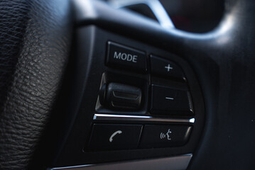 Detailed view of BMW X6 steering wheel controls, featuring buttons for mode, volume, calls, and...
