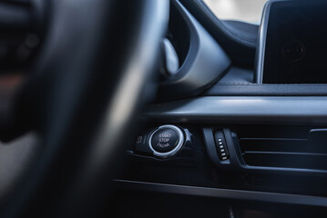 Close up view of the BMW X6 dashboard featuring the Start or Stop Engine button, sleek black and metallic accents, and part of the infotainment screen.