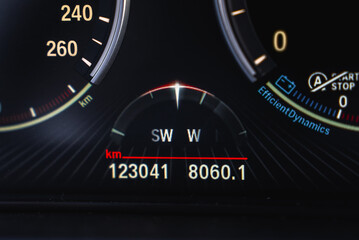 Close up view of the BMW X6 digital instrument cluster showing speedometer, odometer, compass, and EfficientDynamics label with illuminated details.