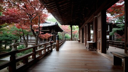 Obraz premium A serene walkway through a traditional Japanese temple garden, showcasing autumn foliage and weathered wood architecture.