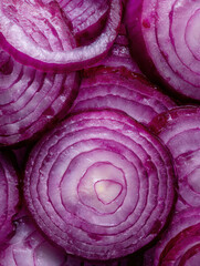 Fototapeta premium Close-up view of fresh sliced red onions showcasing their vibrant color and layers in a uniform pattern found in a kitchen setting