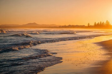 Naklejka premium Golden sunset over ocean waves and sandy beach