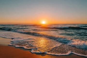 Golden sunset over ocean waves and sandy beach