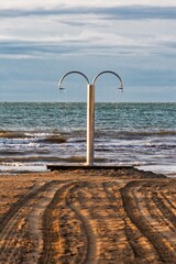 paesaggio marino minimal con doccia sulla spiaggia