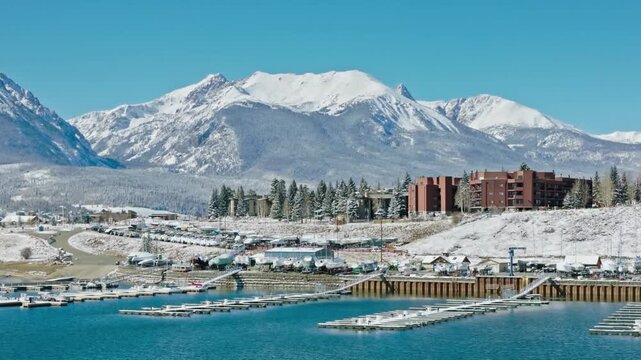 Snowy mountains tower over dillon marina on a bright winter day