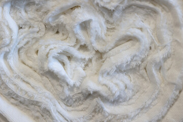 Soft white textiles arranged in a cozy heap showcasing texture and craftsmanship in natural light