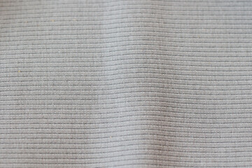 Close-up view of textured fabric showcasing subtle lines and patterns in neutral tones for textile design reference