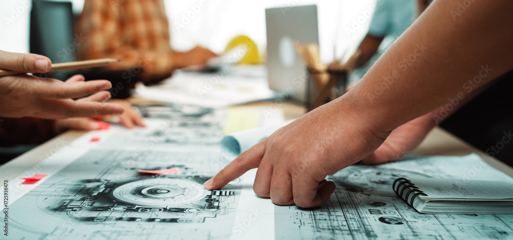 Poster a diverse group of professionals engages in a productive brainstorming session, analyzing blueprints