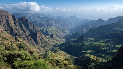 Naklejka premium A breathtaking vista unfolds across a dramatic mountain valley, showcasing rugged peaks and lush green valleys.