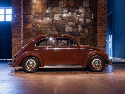 Vintage split-window Volkswagen Beetle side profile, Iconic german classic car in an industrial showroom

