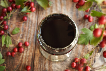 Medicinal wine made of fresh hawthorn berries in a vintage glass cup