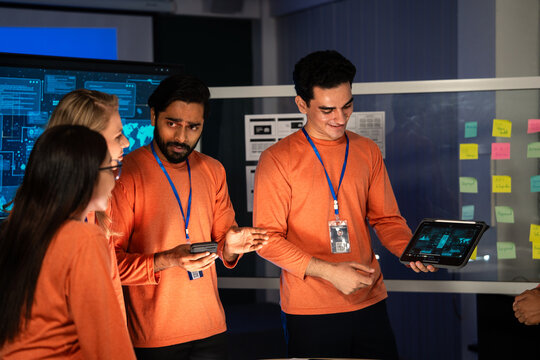 A creative team of engineers and designers presents a mobile application prototype during a product review on tablet, They share ideas, discuss user experience, analyzes features, interface design