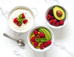 Delicious breakfast bowls with yogurt and avocado, topped with raspberries and mint