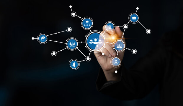 A hand interacts with digital connections and icons in a modern setting, symbolizing technology, business, and communication in a sleek dark environment. Tessel