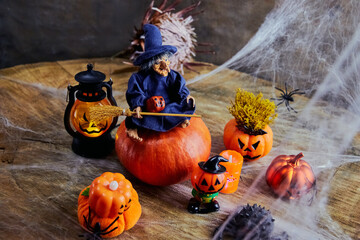 cute witch with a broom on halloween sits on a big pumpkin at a fun pumpkin party in the cobweb forest, All Saints Day, horizontal, creative focus