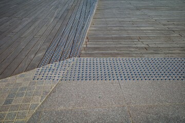 Special paving for the visually impaired on a wooden surface.