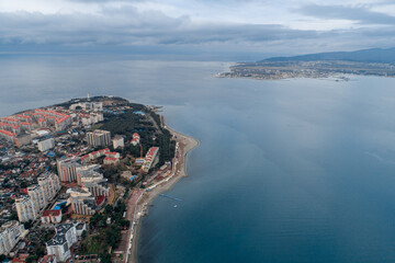 Black Sea, Gelendzhik resort, "Tolsty" cape. Aerial view. Winter. Residential areas on cape. Gelendzhik lighthouse at tip of cape.