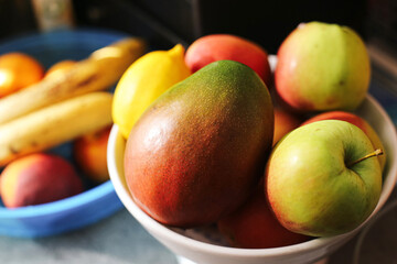 Bowl full of tropical fruits. Fresh mango apples bananas and peaches. Organic colorful harvest from garden. Healthy vitamin food for diet. Natural nutrition and vegetarian lifestyle.