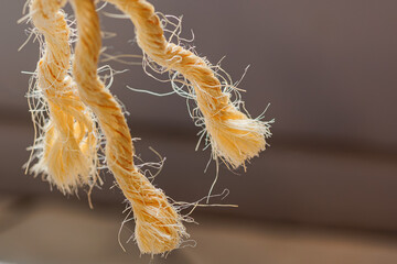 Distressed rope ends hanging down create a feeling of tension and fragility, ideal for nautical...