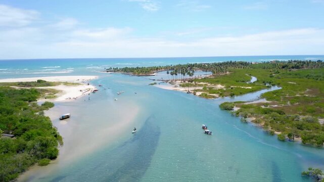 Aerial view of a tropical river meeting the ocean on a sunny day