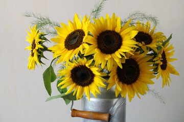 Sunflowers bouquet in vintage milk jug on table