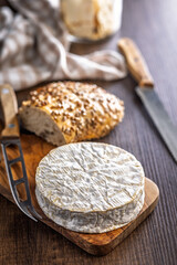 Camembert cheese on wooden table. French cheese with mold on the surface.
