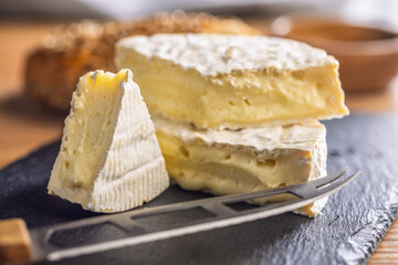 Camembert cheese on cutting board. French cheese with mold on the surface.
