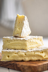 Camembert cheese on wooden cutting board. French cheese with mold on the surface.
