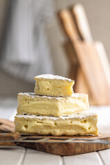 Camembert cheese on wooden cutting board. French cheese with mold on the surface.