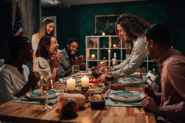 Friends celebrating thanksgiving enjoying roasted turkey at home