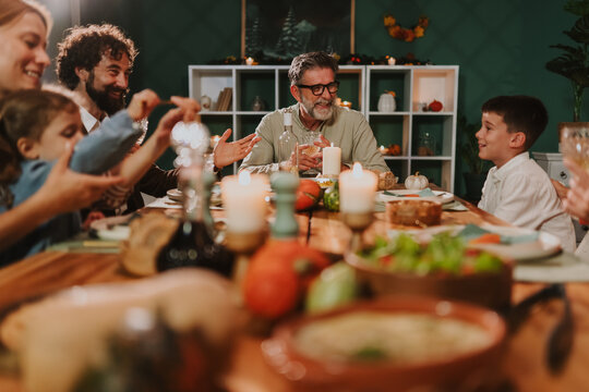 Family enjoying thanksgiving dinner together at home - Powered by Adobe
