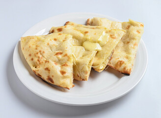 Cheese Naan slices in white plate isolated on white background side view of a Traditional Indian Flatbread with Melted Cheese