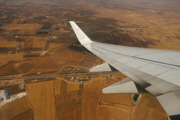 Obraz premium Aerial view of rural landscape and airplane wing in flight over Morocco.