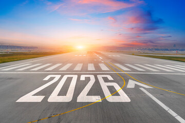 Inscription on the runway 2026 surface of the airport road enjoy travel blue sky white clouds. Concept of travel in the new year, holidays.